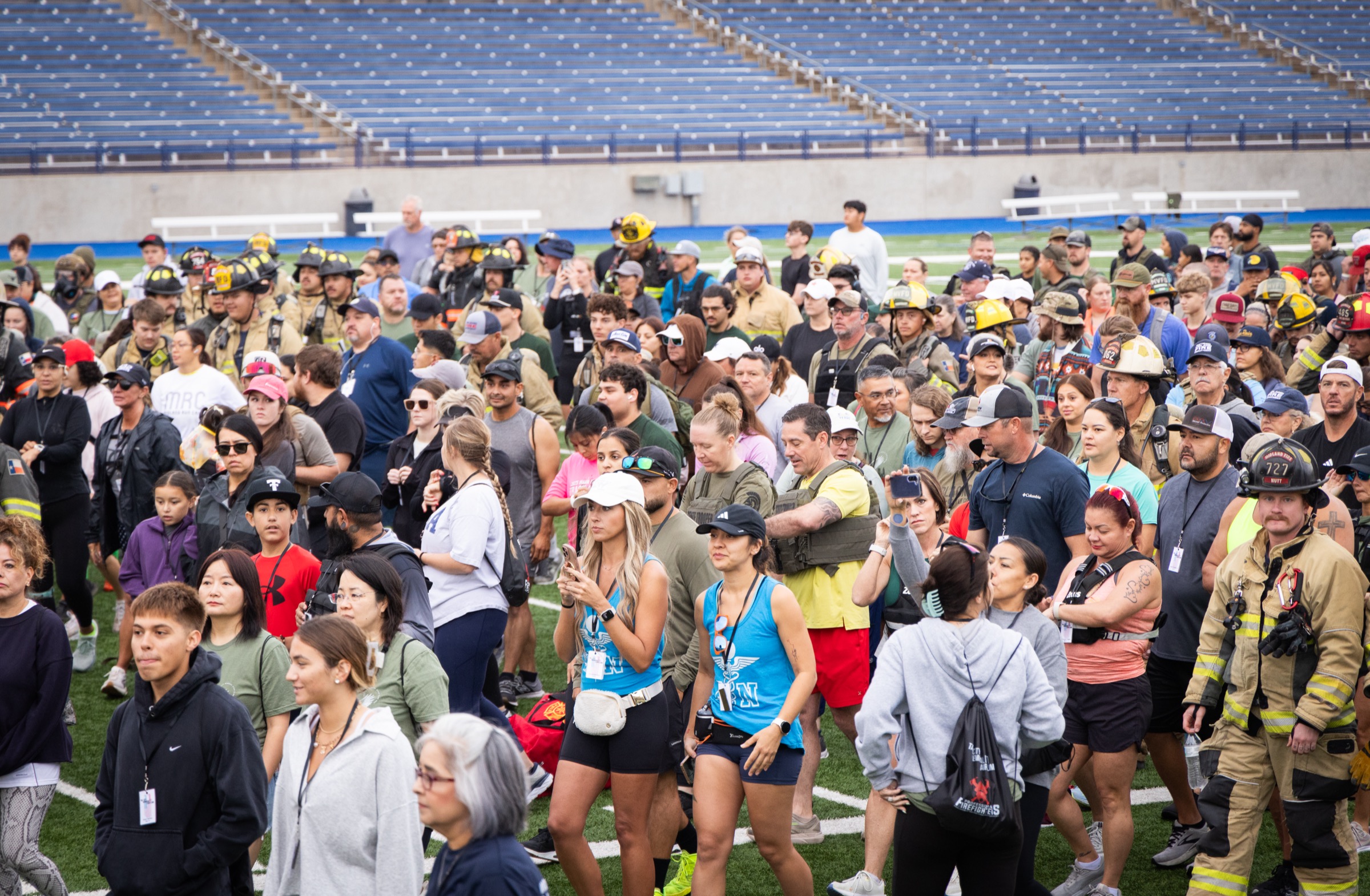 Community members and firefighters gathered on the field at the Tall City Memorial Stair Climb